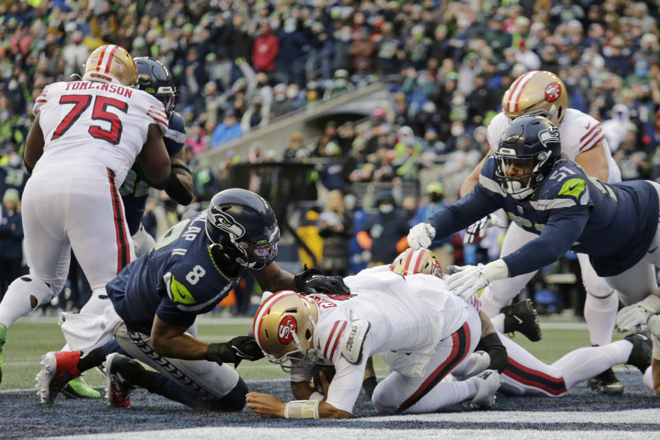 Seattle Seahawks defensive end Carlos Dunlap (8) sacks San Francisco 49ers quarterback Jimmy Garoppolo, center, in the end zone for a safety to tie an NFL football game as Seahawks defensive end Kerry Hyder (51) moves in during the second half Sunday, Dec. 5, 2021, in Seattle. (AP Photo/John Froschauer)