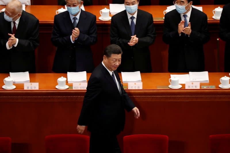 FILE PHOTO: Chinese President Xi Jinping walks past officials wearing face masks following the coronavirus disease (COVID-19) outbreak as he arrives for the opening session of the National People's Congress (NPC) at the Great Hall of the People in Beijing