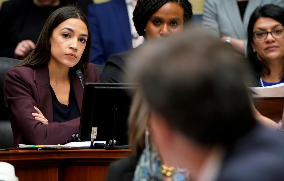 Rep. Alexandria Ocasio-Cortez (D-N.Y.), left, listens to former Trump personal attorney Michael Cohen answer one of her questions at a House Committee on Oversight and Reform hearing on Wednesday. (Photo: Joshua Roberts / Reuters)