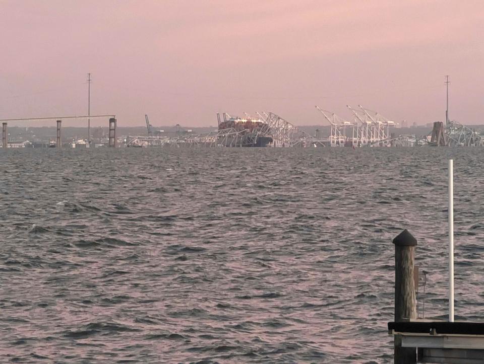 Baltimore's Francis Scott Key Bridge collapse is shown early morning, Tuesday, March 26, 2024 from Riviera Beach, Md. A container ship rammed into a major bridge in Baltimore early Tuesday, causing it to snap in a few places and plunge into the river below. Several vehicles fell into the chilly waters, and rescuers were initially searching for at least seven people. (AP Photo/Nathan Ellgren)