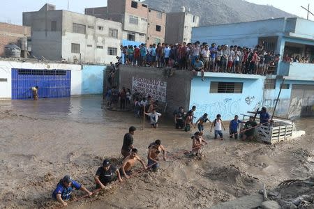 Gente atrapada en un techo es rescatada por la policía tras inundaciones y deslaves, distrito de Huachipa en Lima. 17 de marzo de 2017. REUTERS/Guadalupe Pardo