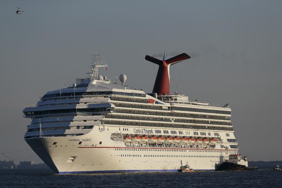 FILE - In this Feb. 14, 2013 file photo the cruise ship Carnival Triumph is towed into Mobile Bay near Dauphin Island, Ala. The Triumph, which has been docked in Alabama since an engine room fire left it disabled for days in the Gulf of Mexico, broke away from its mooring in a Mobile, Ala. shipyard on Wednesday, April 3, 2013. The U.S. Coast Guard tweeted Wednesday afternoon that high winds were likely to blame. (AP Photo/Dave Martin, File)