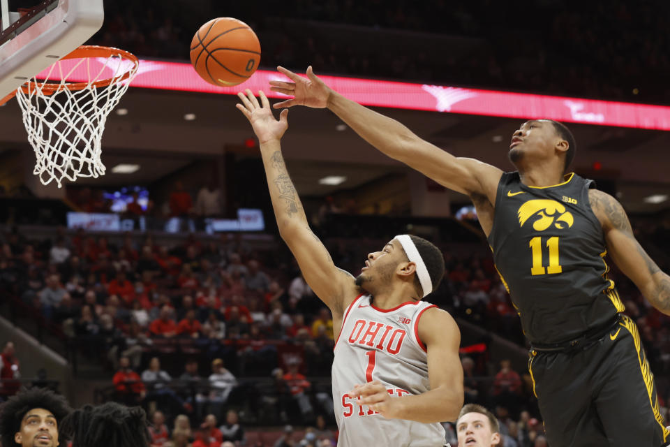 Ohio State's Roddy Gayle, left, shoots past Iowa's Tony Perkins during the second half of an NCAA college basketball game on Saturday, Jan. 21, 2023, in Columbus, Ohio. (AP Photo/Jay LaPrete)