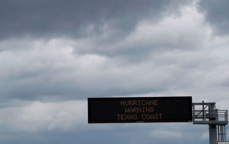 A hurricane warning sign is seen under storm clouds, above a highway approaching Victoria, Texas, U.S. August 25, 2017. REUTERS/Rick Wilking