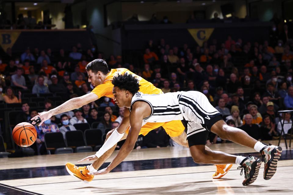 Tennessee guard Santiago Vescovi, rear, and Vanderbilt guard Tyrin Lawrence dive for the ball during the first half of an NCAA college basketball game Tuesday, Jan. 18, 2022, in Nashville, Tenn. (AP Photo/Wade Payne)