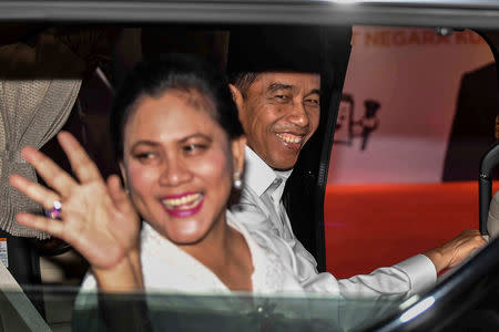 Indonesia's presidential candidate Joko Widodo smiles, as his wife Iriana Widodo waves, as they arrive at Bidakara hotel for taking part a televised debate between presidential candidates ahead the next election in Jakarta, Indonesia, January 17, 2019. Antara Foto/Aprillio Akbar/via REUTERS