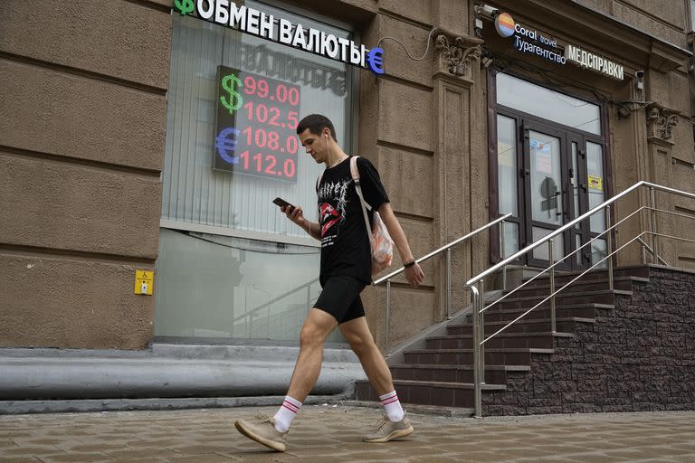 Un hombre pasa frente a una casa de cambio en Moscú, 14 de agosto de 2023. El banco central ruso elevó la tasa de interés en 3,5 puntos el martes 15 de agosto de 2023