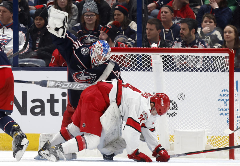 Carolina Hurricanes forward Seth Jarvis, right, interferes with Columbus Blue Jackets goalie Joonas Korpisalo (70) during the second period of an NHL hockey game in Columbus, Ohio, Saturday, Jan. 7, 2023. (AP Photo/Paul Vernon)