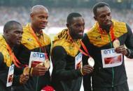 Usain Bolt of Jamaica (R) and teammates Nesta Carter, Asafa Powell, Nickel Ashmeade, gold medallists, pose on the podium after the men's 4 x 100 metres relay event during the 15th IAAF World Championships at the National Stadium in Beijing, China, August 30, 2015. REUTERS/Damir Sagolj