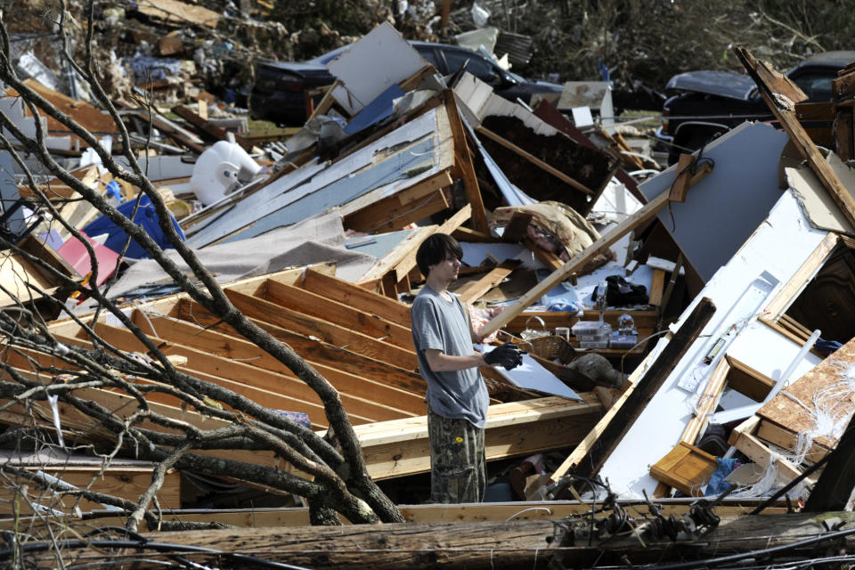 James Scott, 19, pauses while picking through the remains of his home, which was destroyed by a tornado, on Tuesday, Jan. 26, 2021, in Fultondale, Ala. Scott, who survived with his mother and sister, had never lived anywhere else and isn't sure where he will wind up after the storm. (AP Photo/Jay Reeves)