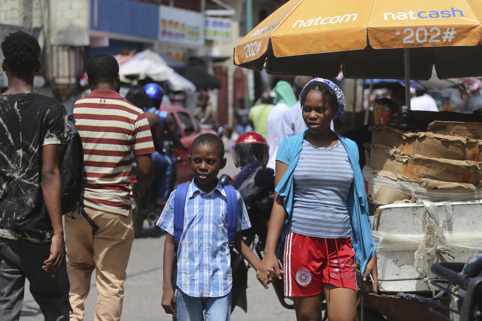 Nayanka Seide accompanies her step-brother Woodberson Seide to his music school in the Delmas 32 neighborhood of Port-au-Prince, Haiti, Saturday, Sept. 23, 2023. They avoided cars, motorcycles, and territory controlled by the gangs whose predation prompted a U.N. Security Council vote this week for the deployment of a multinational armed force. (AP Photo/Odelyn Joseph)