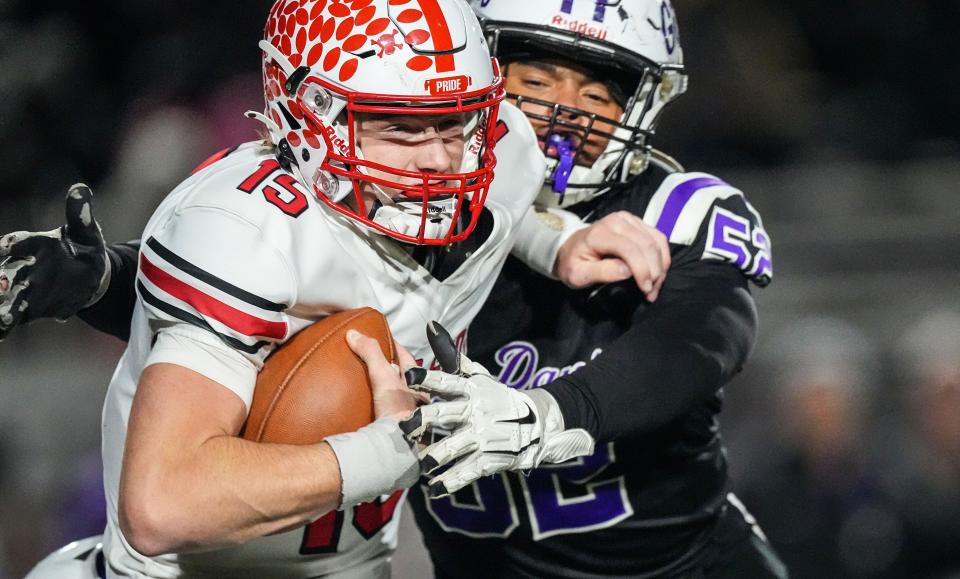 Center Grove Trojans quarterback Tyler Cherry (15) is sacked by Ben Davis Giants defensive lineman Chris Green (52) on Friday, Nov. 17, 2023, during the IHSAA semi state championship game at Ben Davis High School in Indianapolis. The Ben Davis Giants defeated the Center Grove Trojans in overtime, 37-34.