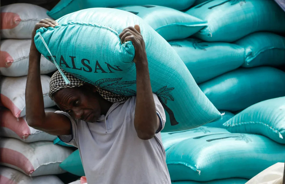 A trader carries a bag of wheat imported from Ukraine on his shoulders at an open-air market in Mogadishu, Somalia.