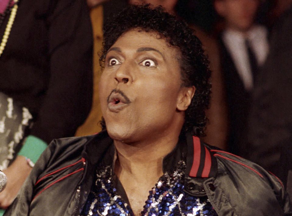 FILE - In this Nov. 13, 1986 file photo, Little Richard poses for the cameras as he is inducted into Rock Walk, a sidewalk collection of handprints and signatures of rock and roll musicians, in Los Angeles. Little Richard, the self-proclaimed “architect of rock ‘n’ roll” whose piercing wail, pounding piano and towering pompadour irrevocably altered popular music while introducing black R&B to white America, has died Saturday, May 9, 2020. (AP Photo/Mark Avery, File)