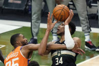 Milwaukee Bucks forward Giannis Antetokounmpo (34) battles under the basket against Phoenix Suns forward Mikal Bridges (25) during the first half of Game 6 of basketball's NBA Finals in Milwaukee, Tuesday, July 20, 2021. (AP Photo/Paul Sancya)