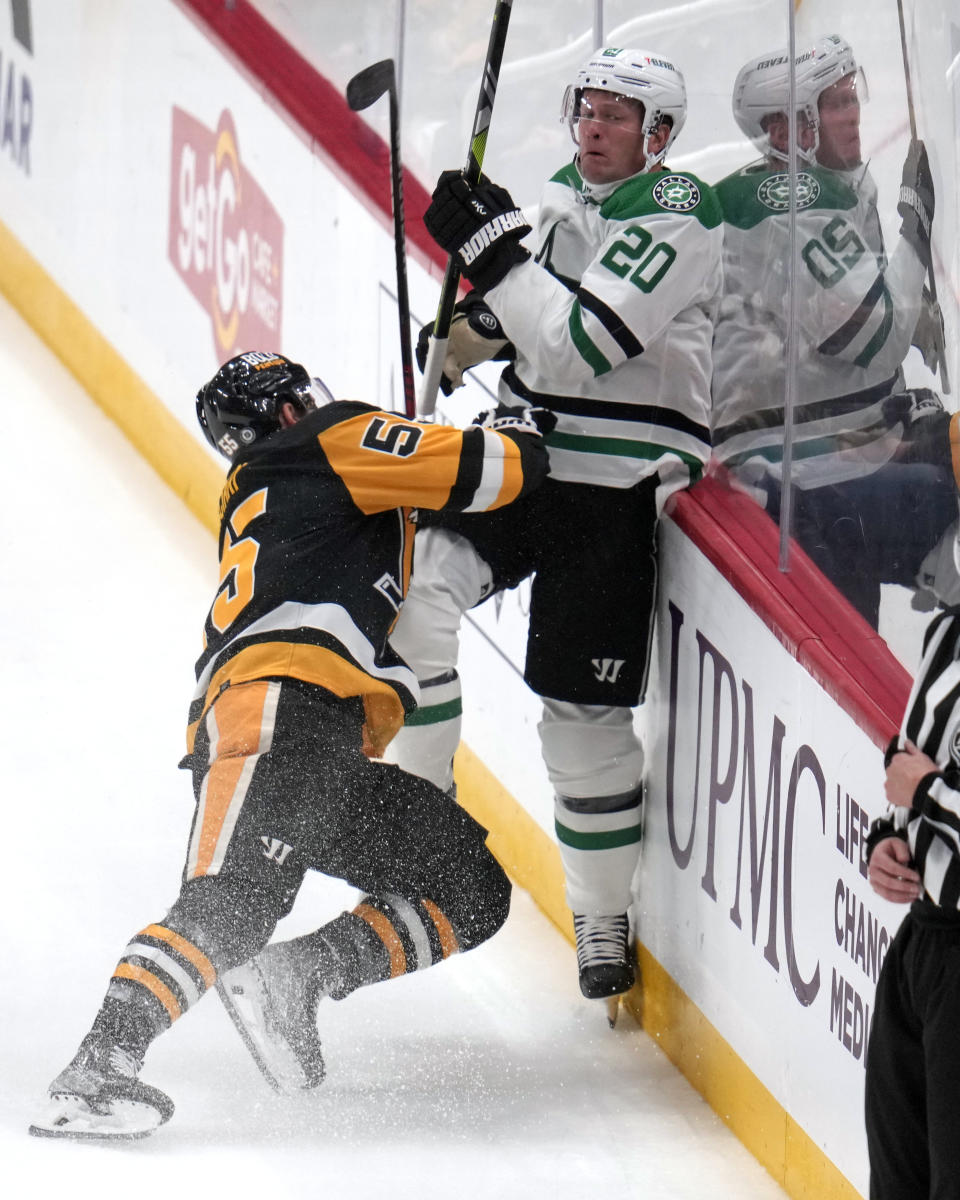 Pittsburgh Penguins' Noel Acciari (55) checks Dallas Stars' Ryan Suter (20) off the puck into the boards during the first period of an NHL hockey game in Pittsburgh, Tuesday, Oct. 24, 2023. (AP Photo/Gene J. Puskar)