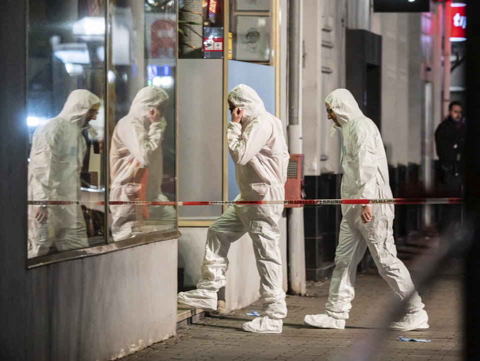 Forensics enter a building at the scene after a shooting in central Hanau, Germany Thursday, Feb. 20, 2020. Eight people were killed in shootings in the German city of Hanau on Wednesday evening, authorities said. (Andreas Arnold/dpa via AP)