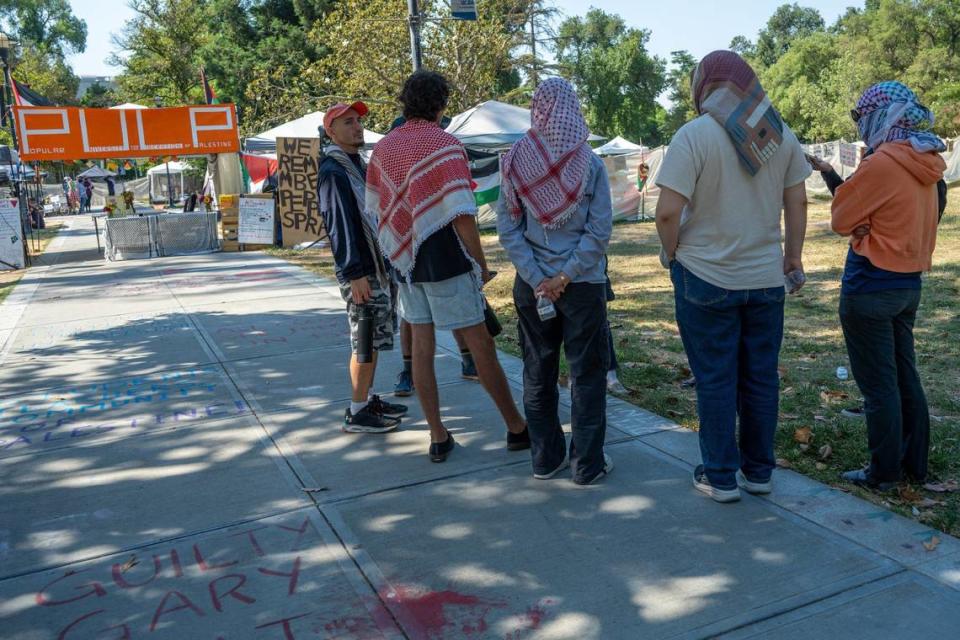 Negotiation team member Beshara Kehdi, left, talks with other protesters from the Davis Popular University for the Liberation of Palestine, known as PULP, after they announced their decampment at a press conference Wednesday at UC Davis.