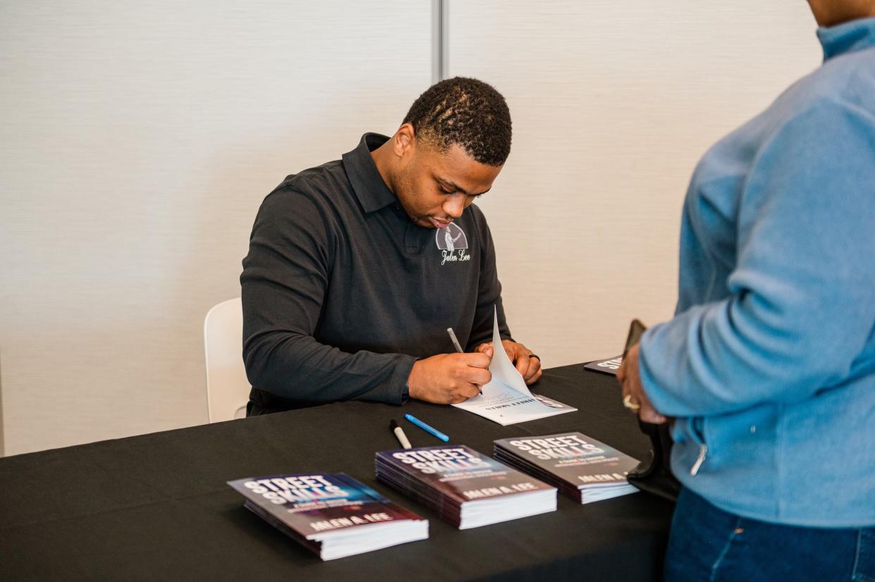 South Bend Police Officer Jalen Lee signs copies of his second book, “Street Skills: a guide to master interactions with the police," on Feb. 11, 2024, at Howard Park in South Bend.