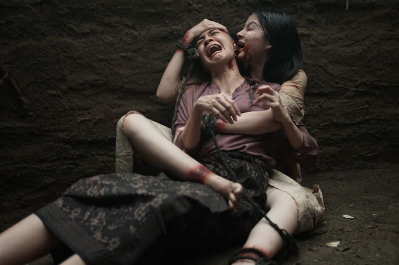 《屍禁》中邪女孩妲拉瘋狂爆咬女傭耳朵，阻止解降頭儀式的進行。（圖／威視電影提供）