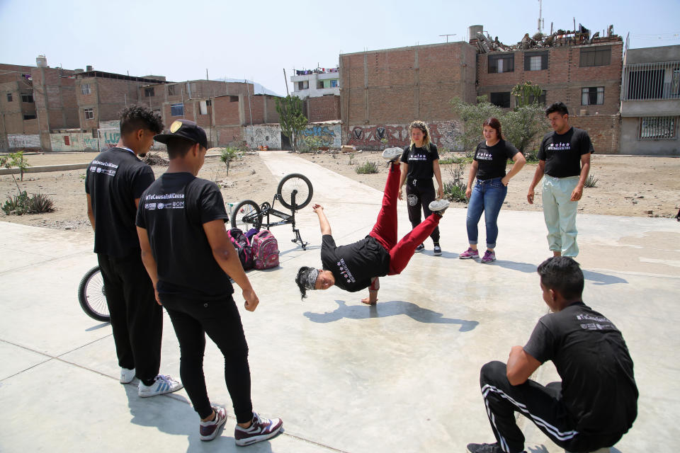 In this Dec. 10, 2018 photo, Venezuelan breakdancer Karin Rojas practices amid other Venezuela breakdancers in Lima, Peru. Rojas' husband Francisco Diaz stands top right, and their dancing partner Angel Fernandez stands second from left. Six days a week, the three work for tips at street intersections for 13-hours, some days earning just $5 dollars. On a good day they net $20. (AP Photo/Mauricio Munoz)