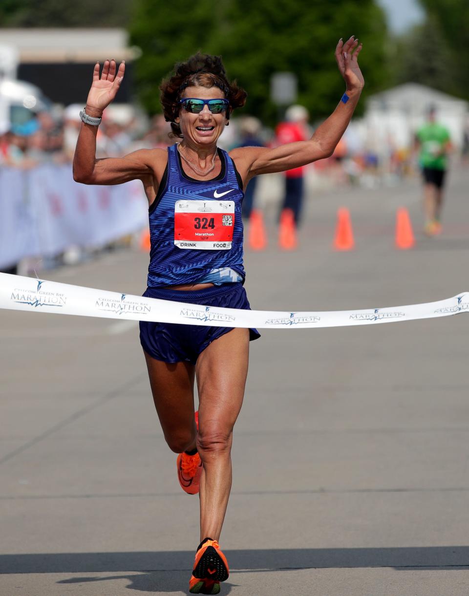 Valentyna Poltavska celebrates as she runs across the finish line of the Cellcom Green Bay Marathon on Sunday.