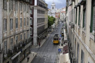 A tram drives through downtown Lisbon, Friday, June 18, 2021. Travel in and out of the Lisbon metropolitan area is to be banned over coming weekends as Portuguese authorities respond to a spike in new COVID-19 cases in the region around the capital. (AP Photo/Armando Franca)