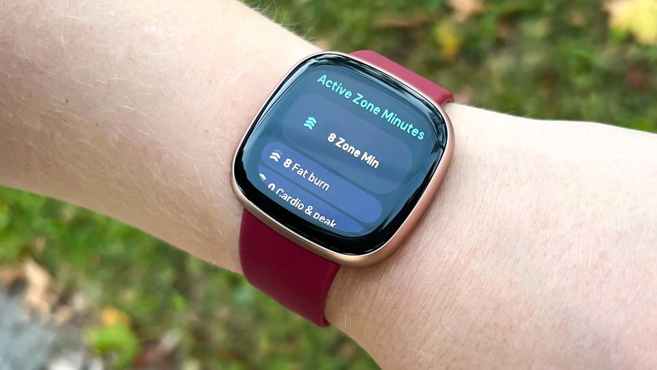 Fitbit Versa 4 on a person's wrist showing Active Zone Minutes overview