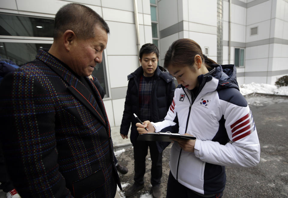Kim Yuna, Vancouver gold medalist for the women's figure skating, signs her autograph for a fan prior to the inaugural ceremony of South Korean national team for the Sochi Winter Olympics in Seoul, South Korea, Thursday, Jan. 23, 2014. South Korea will send 64 athletes to Sochi which will be held from Feb. 7-23. (AP Photo/Lee Jin-man)