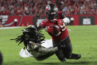 Tampa Bay Buccaneers running back Rachaad White (29) dives into the end zone for a touchdown as New Orleans Saints linebacker Demario Davis (56) covers late in the second half of an NFL football game in Tampa, Fla., Monday, Dec. 5, 2022. The Buccaneers won 17-16. (AP Photo/Mark LoMoglio)