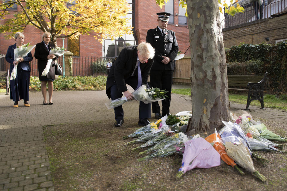 Britain's Prime Minister Boris Johnson lays flowers during a visit to Thurrock Council Offices, England, Monday Oct. 28, 2019. British police say they have arrested a fourth person in connection with the deaths of 39 people found in a truck in southeast England in one of Britain's worst human-smuggling tragedies. (Stefan Rousseau/Pool via AP)