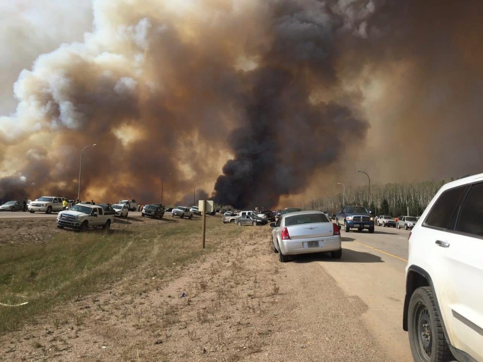 Abandoned vehicles litter Highway 63, south of Fort McMurray, Alta., as residents fled the wildfire engulfing the city on Tuesday, May 2, 2016. THE CANADIAN PRESS/Brian Langton