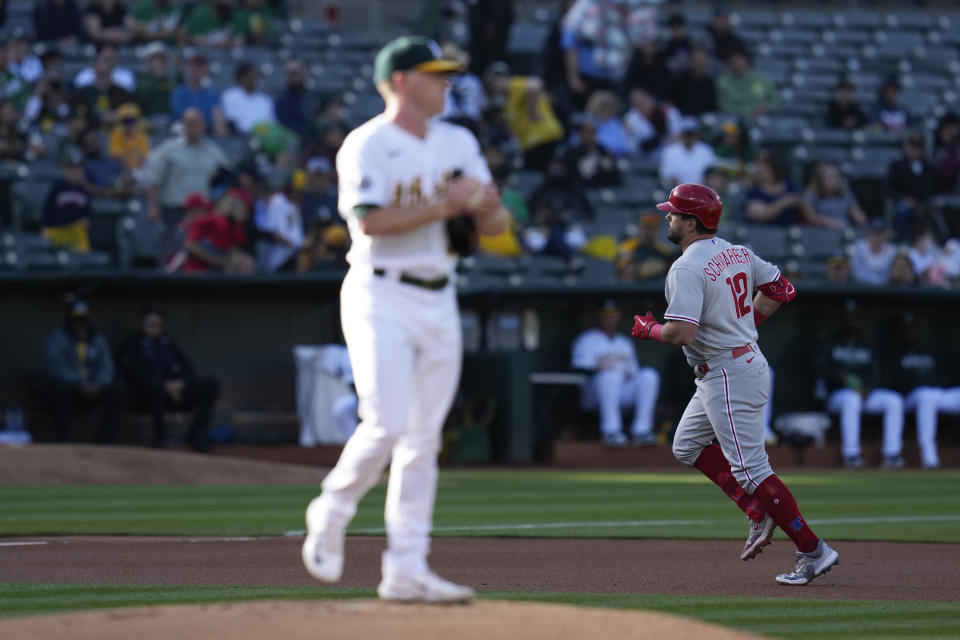 Philadelphia Phillies' Kyle Schwarber, right, runs the bases after hitting a solo home run against Oakland Athletics pitcher JP Sears, foreground, during the first inning of a baseball game in Oakland, Calif., Friday, June 16, 2023. (AP Photo/Godofredo A. Vásquez)