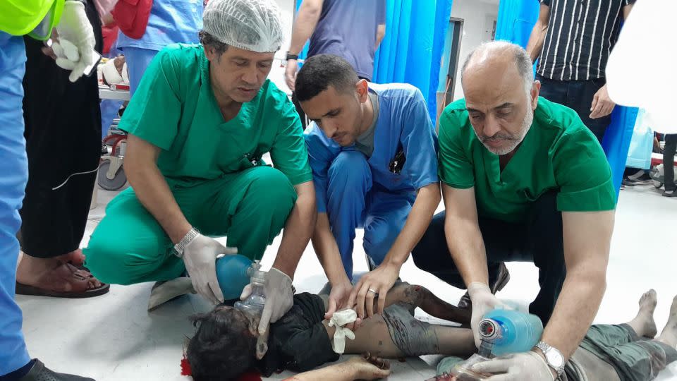 Palestinian surgeon Al-Bursh (left) is pictured treating a wounded Palestinian child at a hospital in Gaza. - Ministry of Health in Gaza