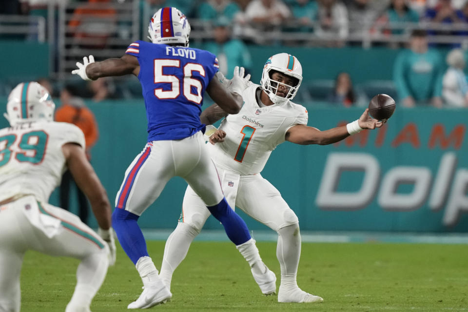 Miami Dolphins quarterback Tua Tagovailoa (1) throws a pass around Buffalo Bills defensive end Leonard Floyd (56) during the first half of an NFL football game, Sunday, Jan. 7, 2024, in Miami Gardens, Fla. (AP Photo/Lynne Sladky)