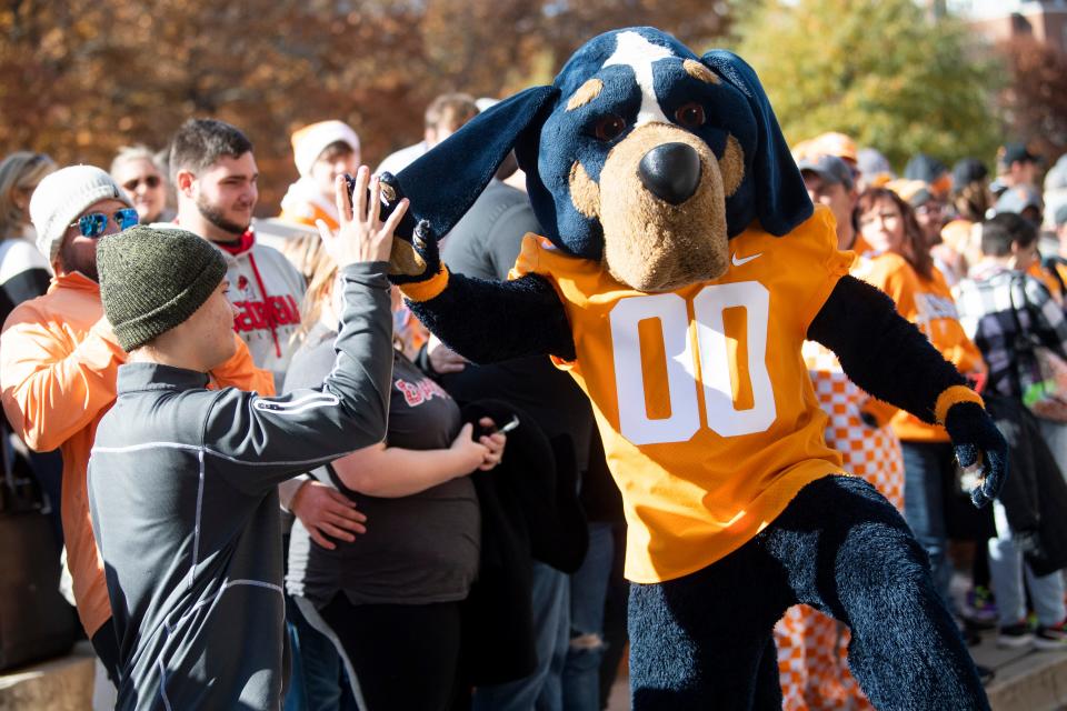 Smokey high fives fans during the Vol Walk before a football game against the Georgia Bulldogs at Neyland Stadium in Knoxville, Tenn. on Saturday, Nov. 13, 2021.