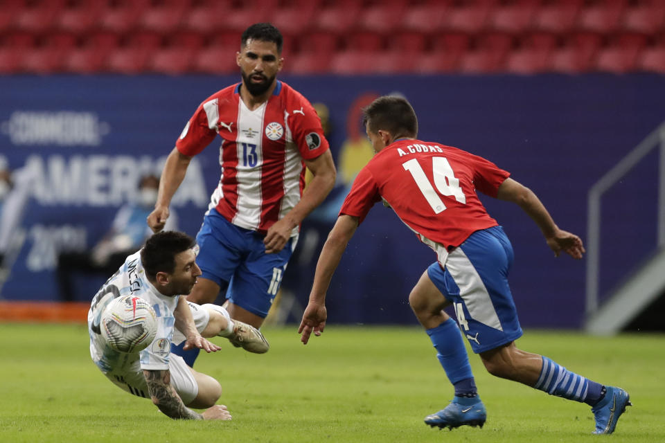 Argentina's Lionel Messi, left, falls during a Copa America soccer match against Paraguay at the National stadium in Brasilia, Brazil, Monday, June 21, 2021. (AP Photo/Eraldo Peres)