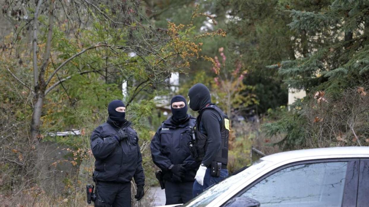 German special police forces stand guard and patrol in a neighbourhood in south western Berlin on December 7, 2022 as part of nationwide early morning raids against members of a far-right 