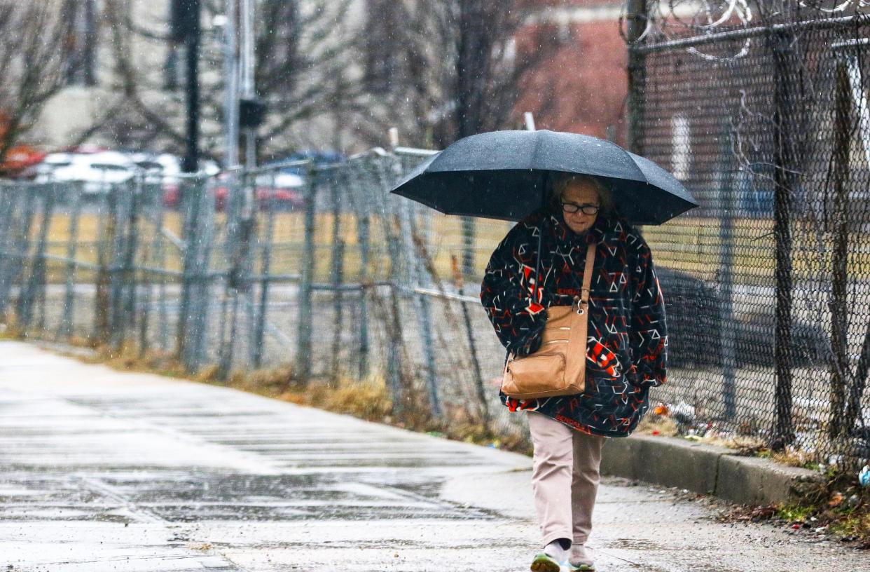 A woman walks along Marshall Avenue as rain falls Tuesday February 22, 2022. The National Weather Service has extended its flood watch, in effect now until 6 a.m. Wednesday.Â 
