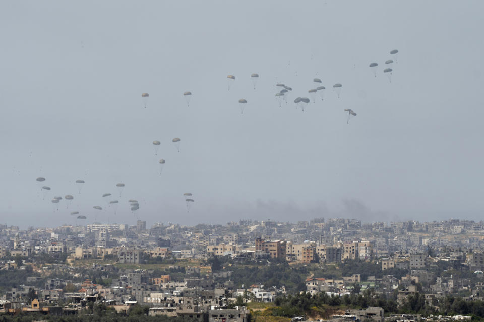 Parachutes drop supplies into the northern Gaza Strip, as seen from southern Israel, Wednesday, March 27, 2024. (AP Photo/Ohad Zwigenberg)