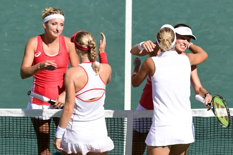 Ekaterina Makarova (2nd left) and Elena Vesnina shake hands with Martina Hingis (right) and Timea Bacsinszky after their match