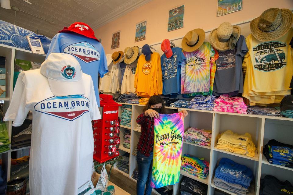 Ellie Kubaska of Oakhurst, cashier, organizes Ocean Grove t-shirts for sale at The Emporium in Ocean Grove, NJ Friday, May 20, 2022. 