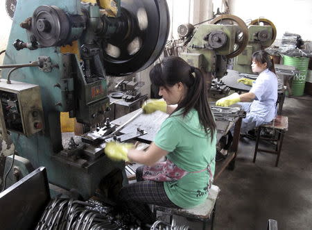 Workers make metal parts at a factory of the Changzhou Wujin Zhengda Vehicle Industry Co. Ltd in Changzhou, Jiangsu province, China, July 9, 2015. REUTERS/John Ruwitch