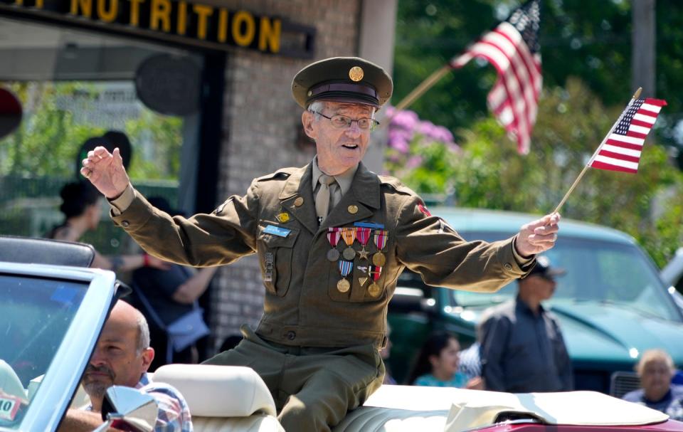 World War II veteran Roger Desjardins waves to the crowd while serving as the grand marshal of North Providence's Memorial Day parade last May.