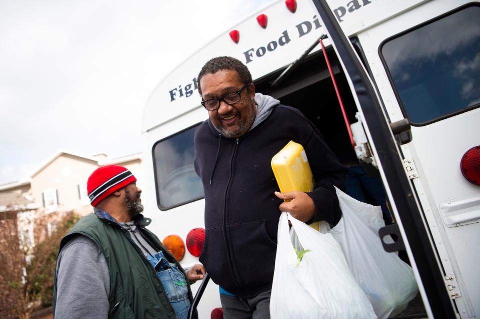 James Thompson walks off BattleField Farm’s veggie bus with his selections.