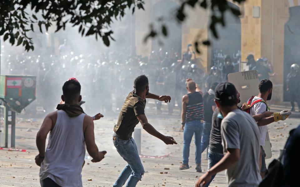 Lebanese protesters hurl rocks towards security forces during clashes in downtown Beirut: AFP via Getty Images