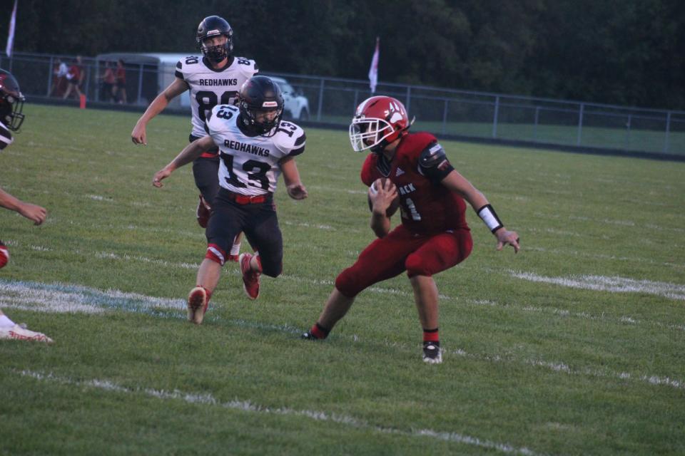 Laingsburg senior running back Jackson Audretsch (No. 11) carries the ball while Saranac junior Carson Hardy (No. 13) tries to tackle him during a varsity football game Friday, Sept. 22, at Laingsburg High School. Saranac won the game, 28-20.