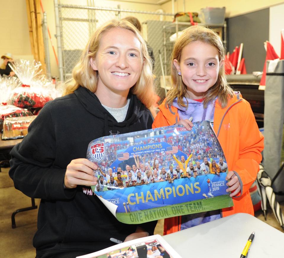 Sam Mewis autographs a poster of her championship team for Emma Stafford.