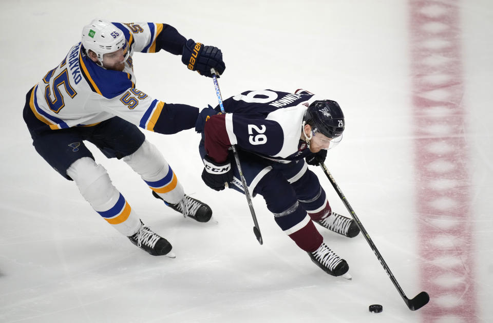 St. Louis Blues defenseman Colton Parayko, left, pursues Colorado Avalanche center Nathan MacKinnon as he collects the puck in the first period of an NHL hockey game Tuesday, April 26, 2022, in Denver. (AP Photo/David Zalubowski)