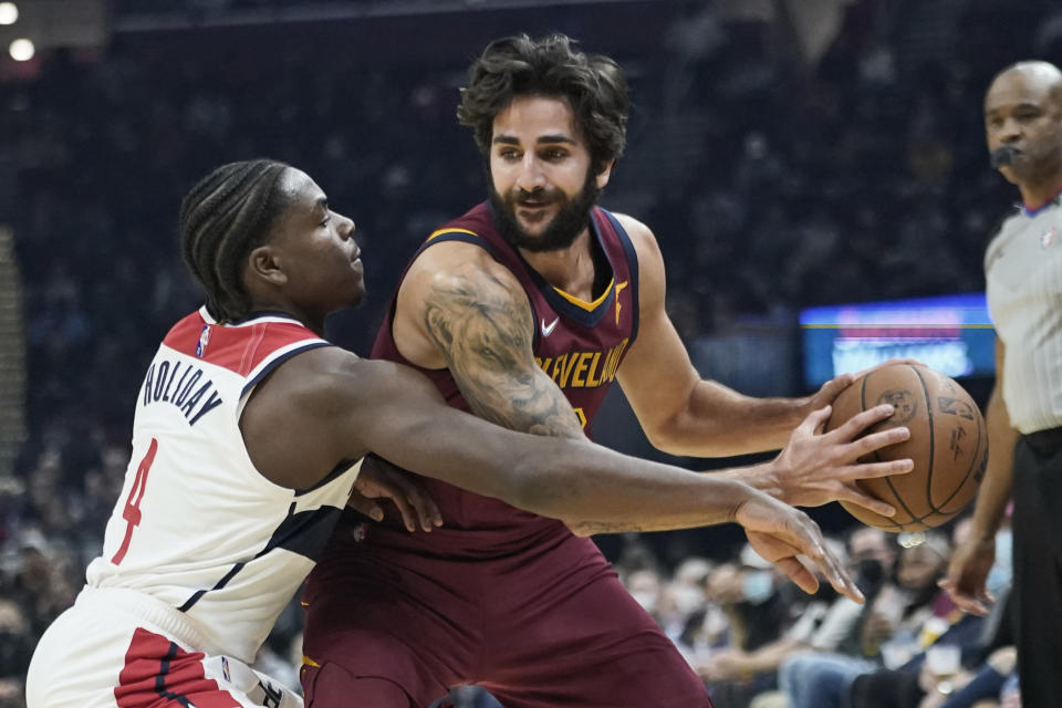 Washington Wizards' Aaron Holiday (4) tries to knock the ball loose from Cleveland Cavaliers' Ricky Rubio (3) in the first half of an NBA basketball game, Wednesday, Nov. 10, 2021, in Cleveland. (AP Photo/Tony Dejak)